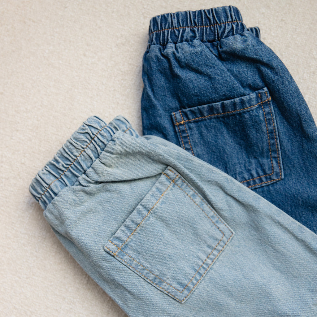 Pair of blue jeans on a beige surface